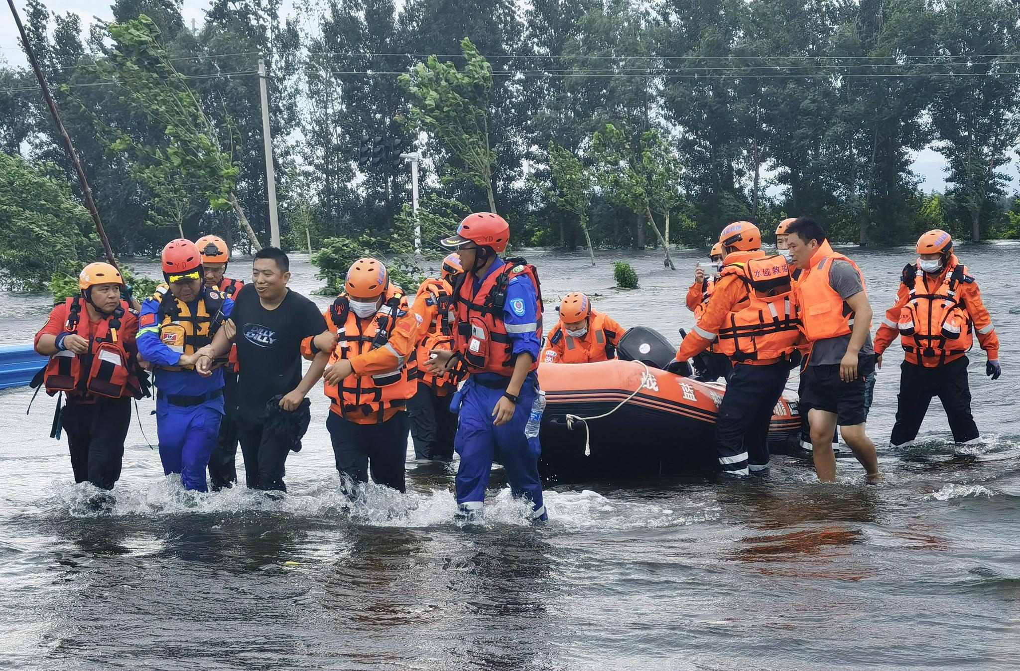 救援人员将一名滞留的落水群众救回傅庄堤上(手机照片,7月29日摄).