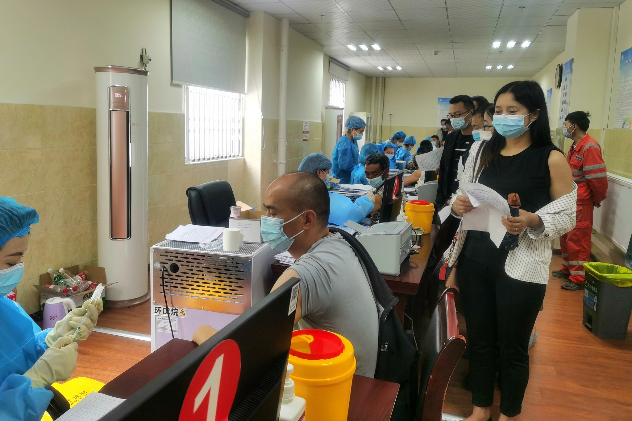 人们在四川省甘孜州康定市民族医院接种点接种新冠肺炎疫苗(7月27日摄