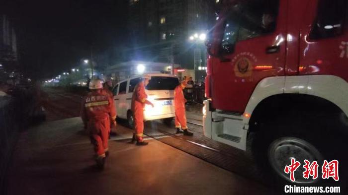 消防员利用抢险救援车对被困面包车实施拖拽。　李文宁 摄