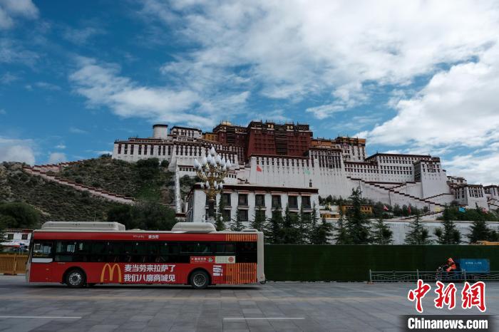 图为麦当劳广告公交车途径拉萨布达拉宫广场。江飞波 摄