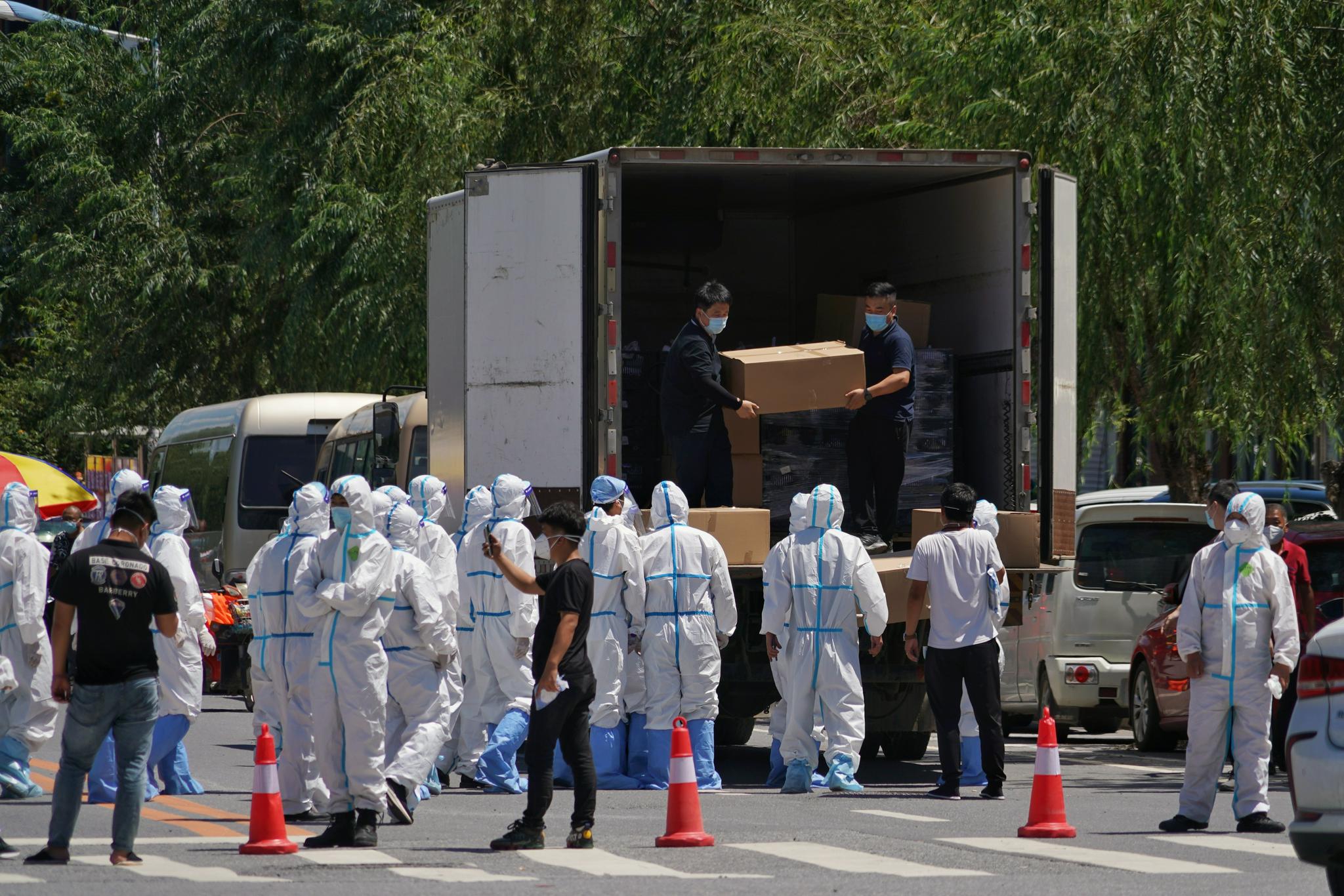 工作人员正从车上搬运物资。本组图片均由新京报记者 裴剑飞 摄