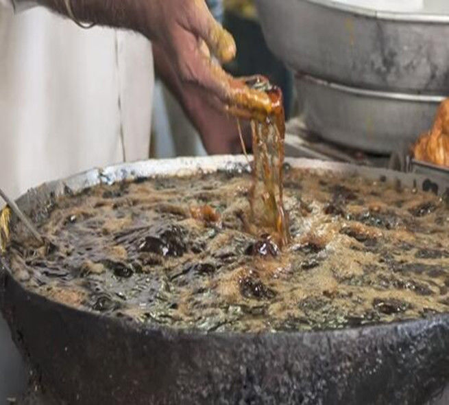 摆摊大叔把手伸进热油锅里炸鱼块,把在场顾客都看傻眼了