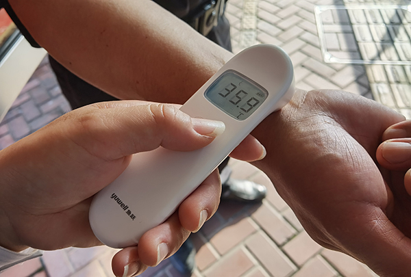 在中运量71路申昆路枢纽站，工作人员开始为乘客测量体温。