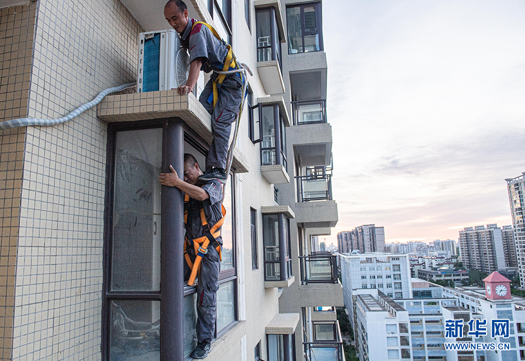 7月29日,袁流伟在海口秀英区一栋高层住宅安装空调外机时进行高空