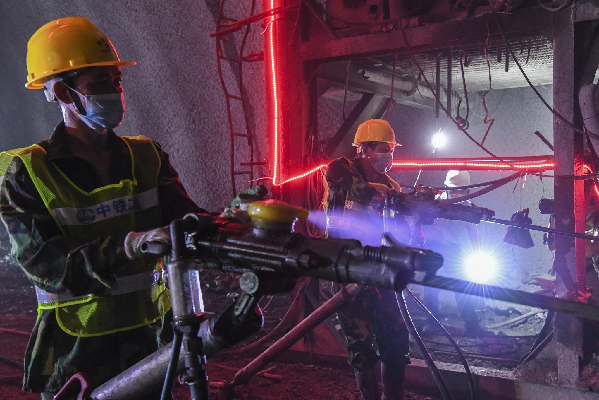 8月2日,在位于广西河池的贵南高铁德庆隧道内,工人用风枪在掌子面打