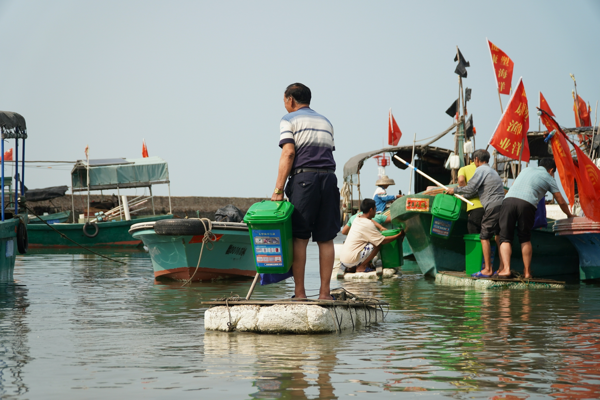 昌江昌化港，参与渔业垃圾打捞项目的渔民带着垃圾桶出海作业。陶兴图