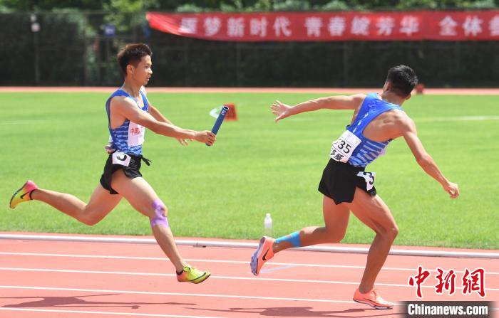 图为:选手在男子4×400米接力决赛中接棒. 王刚 摄