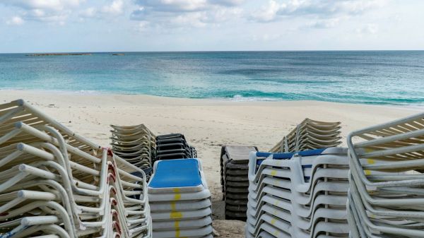 摞起来的躺椅被堆置在空无一人的巴哈马拿骚海滩上。（彭博新闻社网站）
