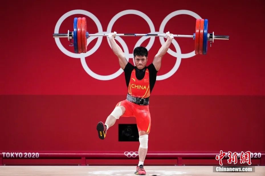 北京时间25日，东京奥运会男子举重61公斤级比赛现场。图为挺举比赛中，李发彬“金鸡独立”举起166公斤。图片来源：视觉中国
