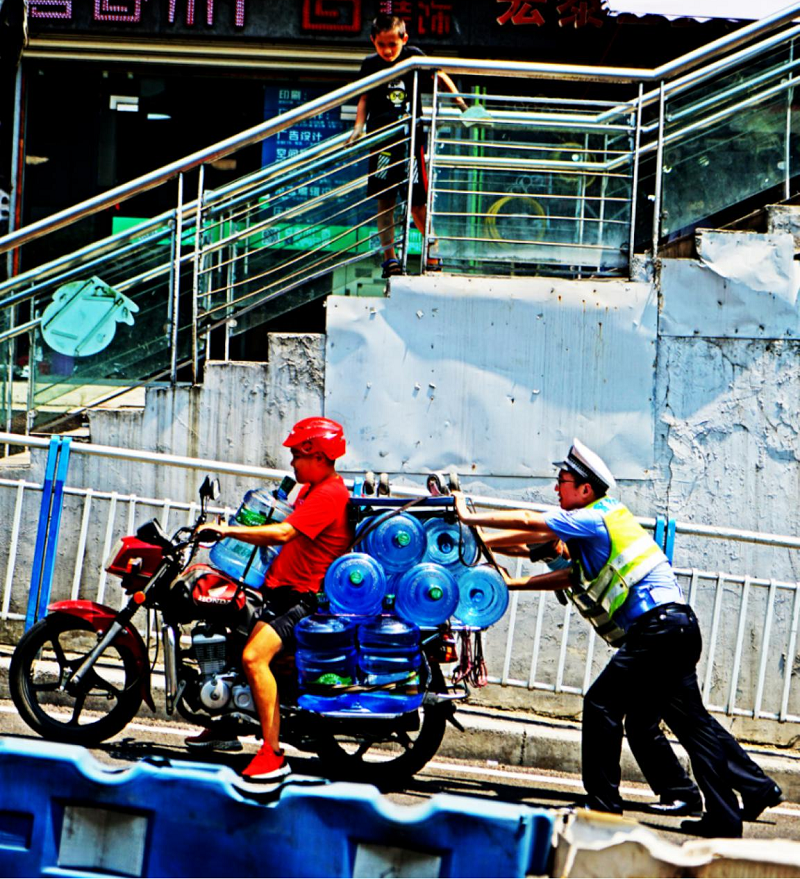 张雨,庞义猛帮忙推摩托车上坡(央广网发 江北区公安分局供图)