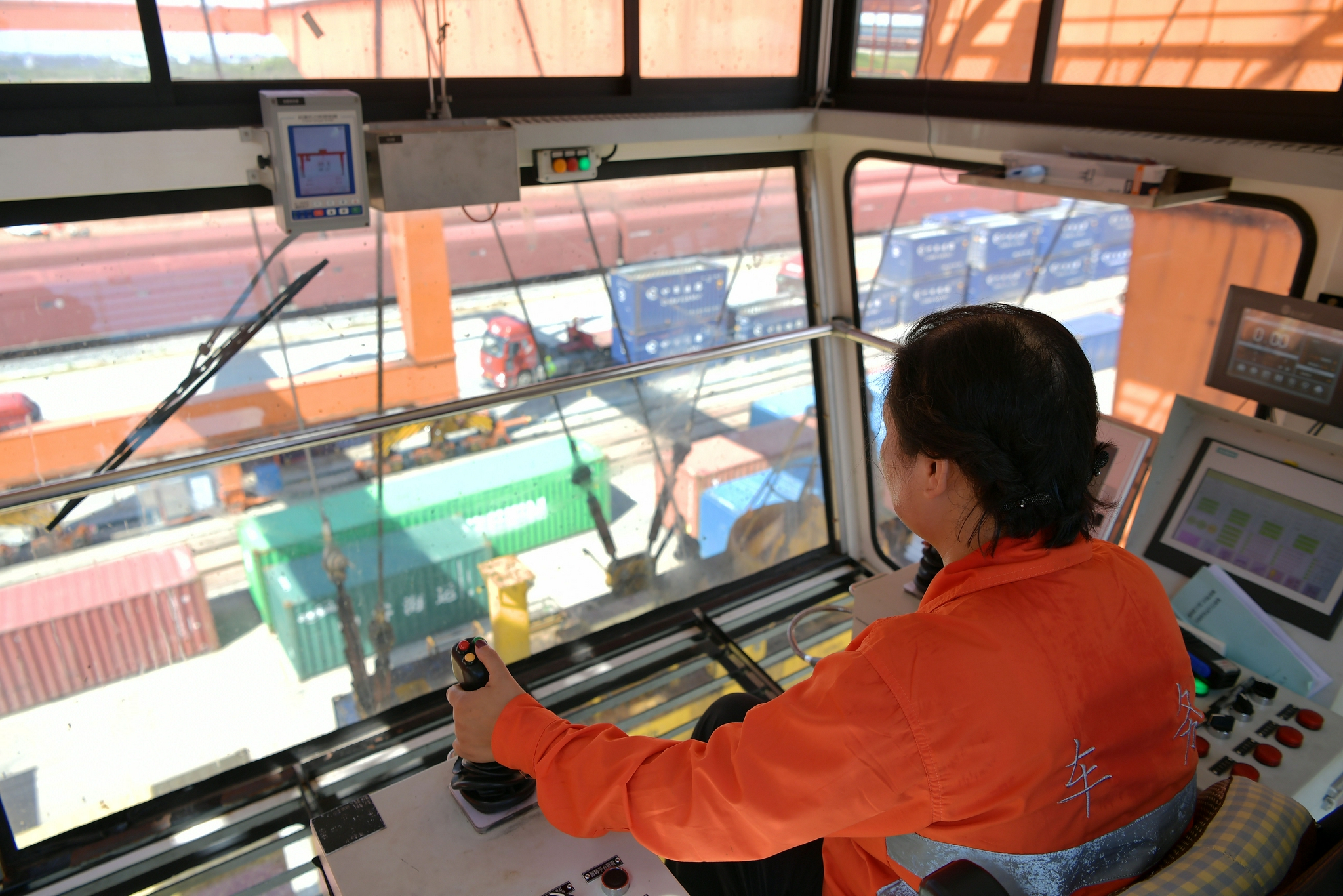 在江西南昌县向塘铁路物流基地,吴海英在龙门吊操作室操控起吊集装箱