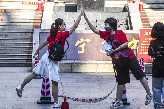 6月7日，2021年高考拉开帷幕。在广西南宁市第二中学新民校区考点，老师（左）与考生击掌。新华社记者 曹祎铭/摄