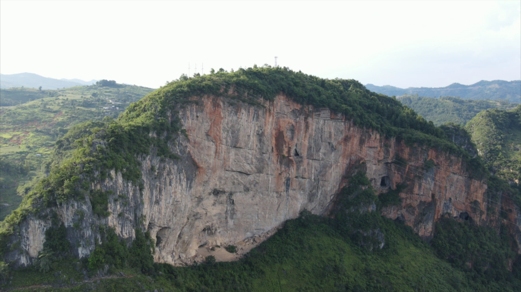 这座山被当地人称为“红岩山”，红岩岩画就在悬崖底部。（新华社记者郑明鸿摄）