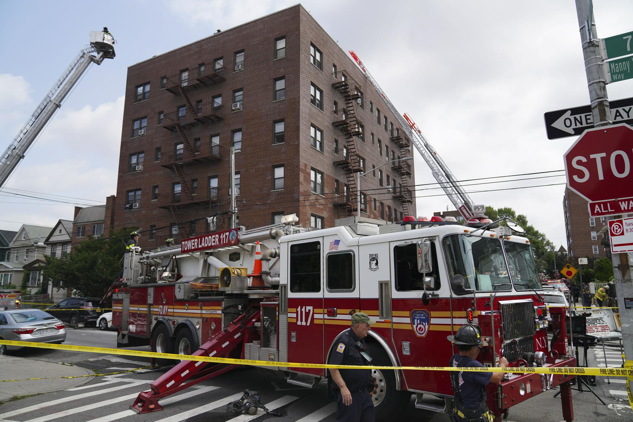 8月10日,消防员在美国纽约发生火灾的居民楼附近工作.