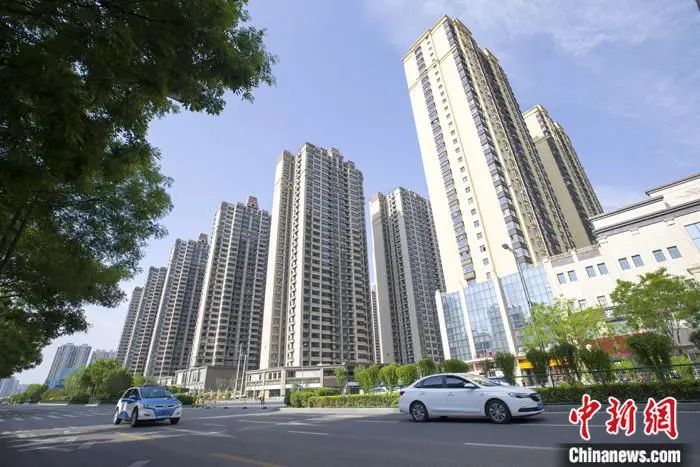 资料图:车辆从一楼盘前经过。中新社记者张云摄