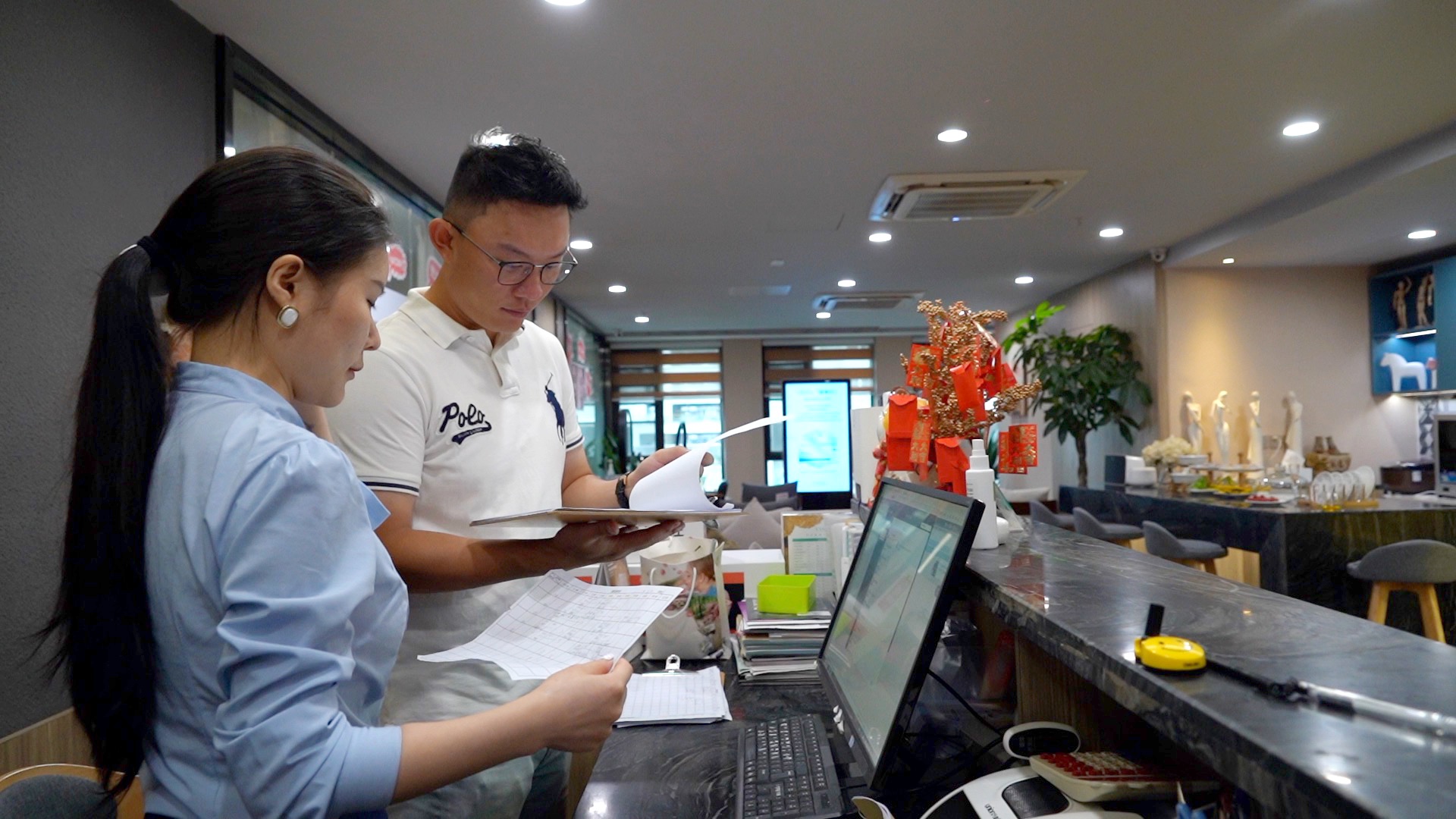 图为林京翰(右)在与同事进行工作交流.新华社记者 尹恒 摄