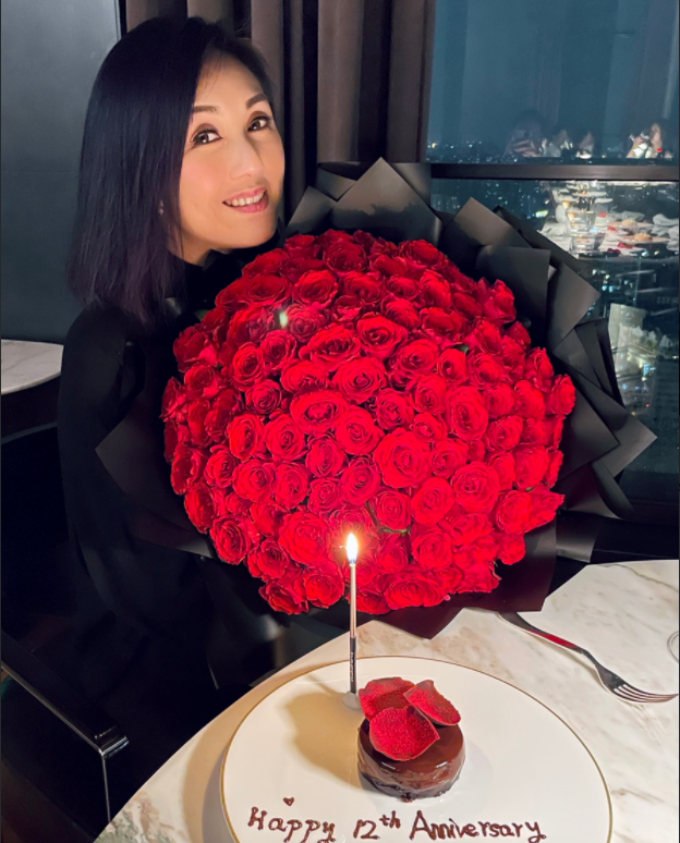 香槟以及一个小小的玫瑰花瓣蛋糕,装蛋糕的餐具上还写着结婚十二周年