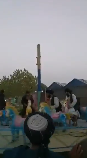 塔利班士兵游乐园内玩碰碰车：手握长枪 欢呼大笑（现场）休闲区蓝鸢梦想 - Www.slyday.coM