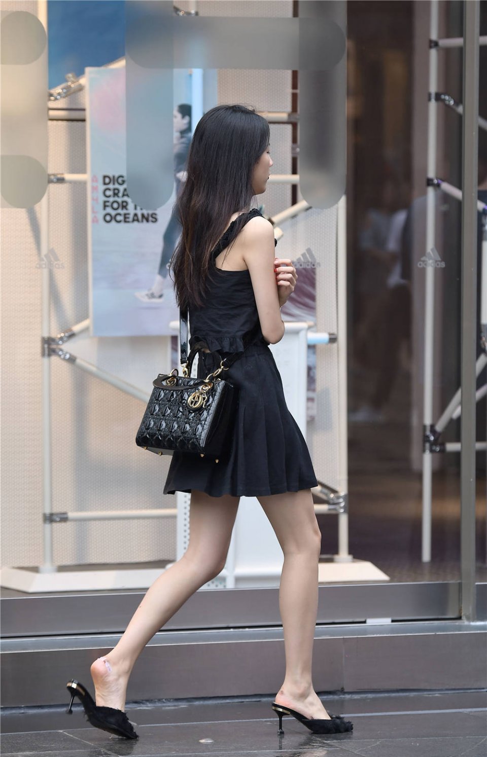 穿着百褶高腰短裙,搭配一双黑色尖头细跟凉拖,有点特别的味道