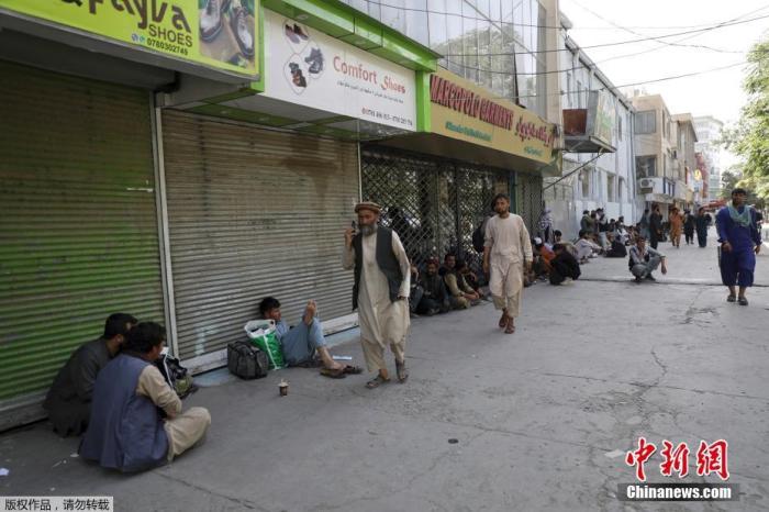 图3：当地时间8月15日，阿富汗首都喀布尔，民众在一个集市排队，等待从附近银行取钱。