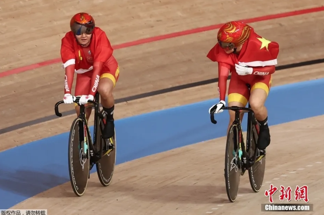 东京奥运会场地自行车女子团体争先赛中，由钟天使和鲍珊菊组成的中国队以31秒895夺得冠军。图为钟天使（左）和鲍珊菊（右）庆祝胜利。