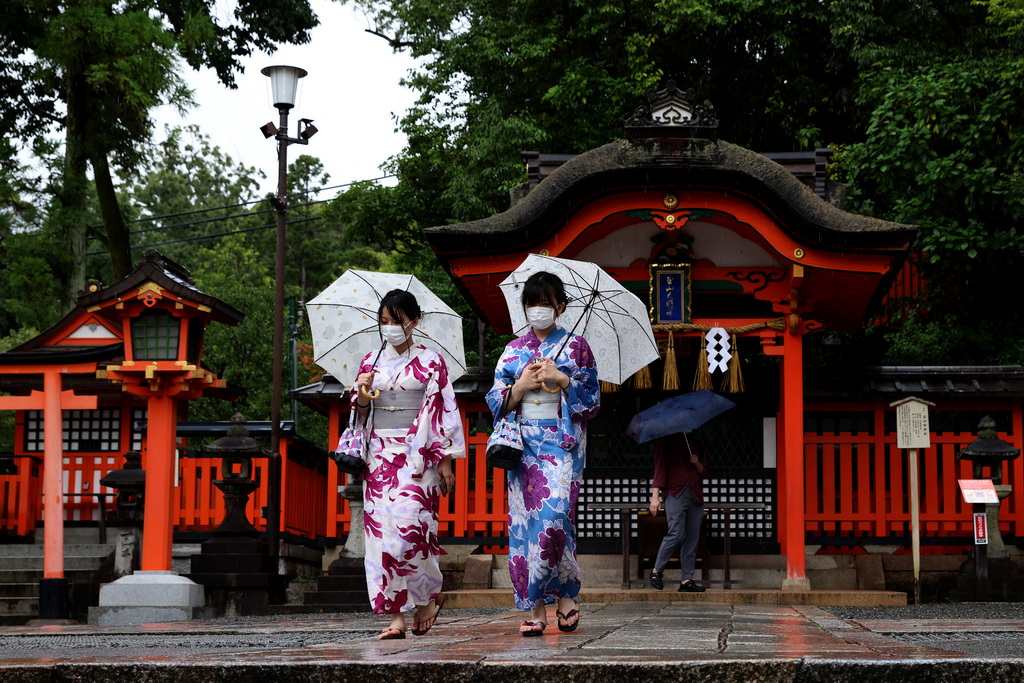 当地时间2021年8月20日，日本京都，民众戴口罩雨中行走。视觉中国图