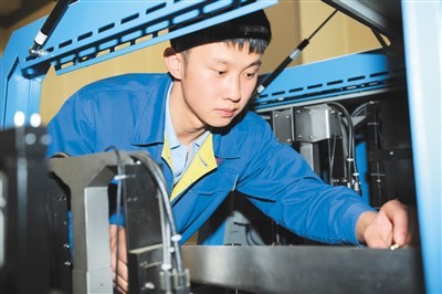 沈币公司钳工高级技师张文良在车间调试造币专用设备. 沈币公司供图