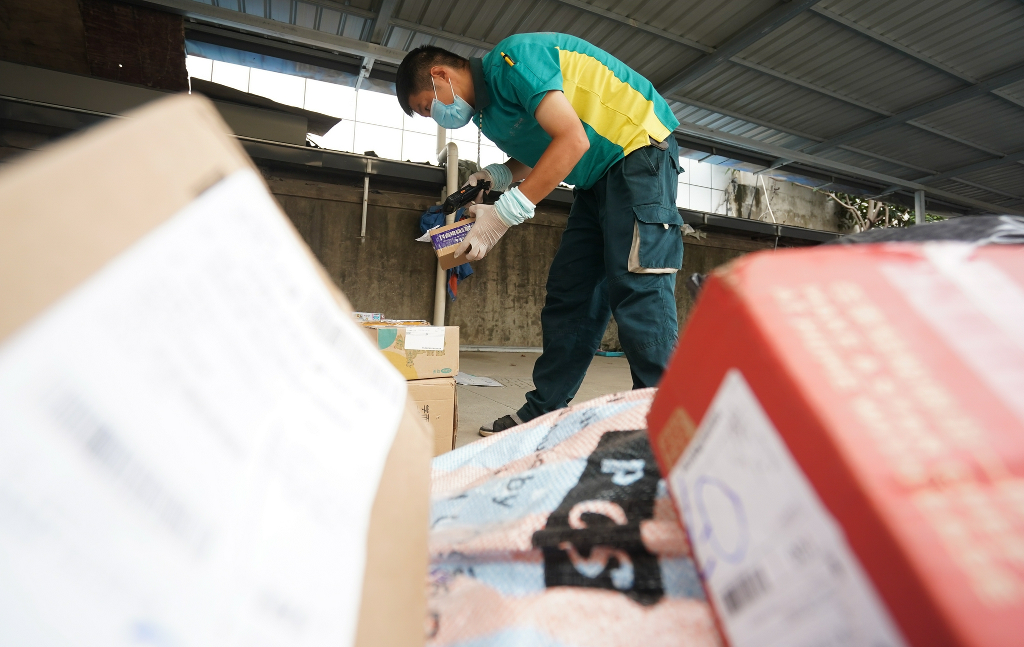 8月26日,在江宁区禄口街道一处邮政快递投递部,工作人员在分拣快. .