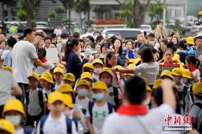 资料图：新生家长们目送学生进入校园。 中新社记者 张瑶 摄