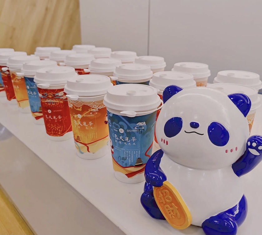 名为"丁丁猫"的蓝色熊猫是茶百道的品牌ip,它在门面,菜单,宣传物料等