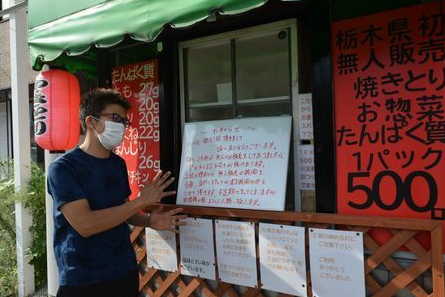 菊地寿洋在停业无人收银烤串店前介绍情况（图片来源：日媒）
