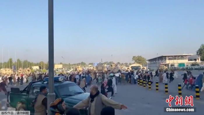 当地时间8月16日，准备撤离的人群跑向喀布尔机场的航站楼。
