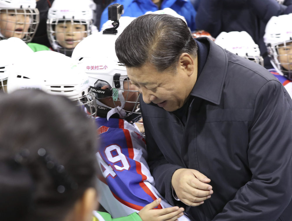 ↑2017年2月24日，习近平在北京市五棵松体育中心同青少年冰球爱好者“撞肩”，表示相互问候。