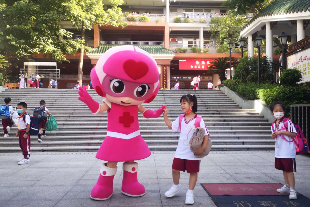 今天上午,协和小学,穿着开心超人的人偶服的老师在校门口欢迎同学返校