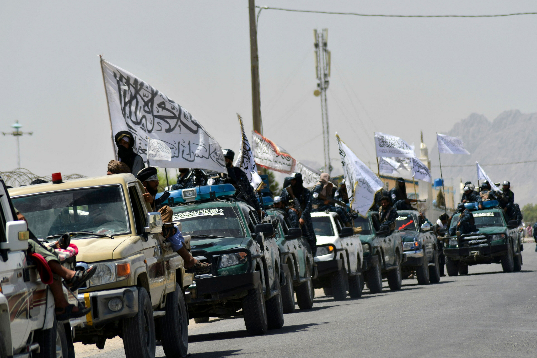当地时间2021年9月1日，塔利班士兵站在车上挥舞着白色旗帜。