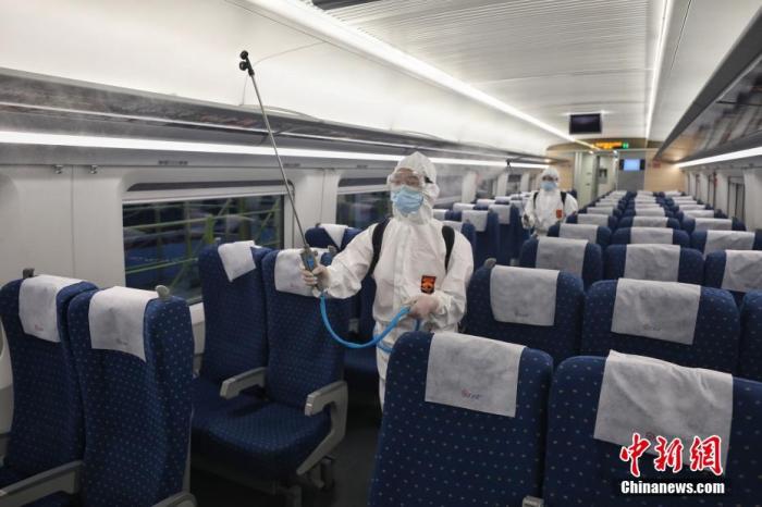资料图：疾控工作人员对高铁动车进行喷洒消毒。 中新社记者 瞿宏伦 摄