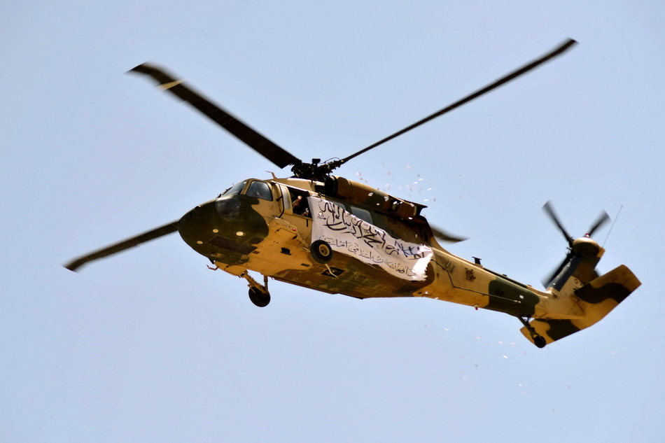 当地时间2021年9月1日，一架悬挂着塔利班旗帜黑鹰直升机飞过坎大哈上空。