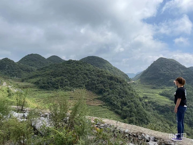 马艺珈伊指向远处山丘，自行车赛道还要再拐几个弯（总台央广记者 任梦岩 摄）