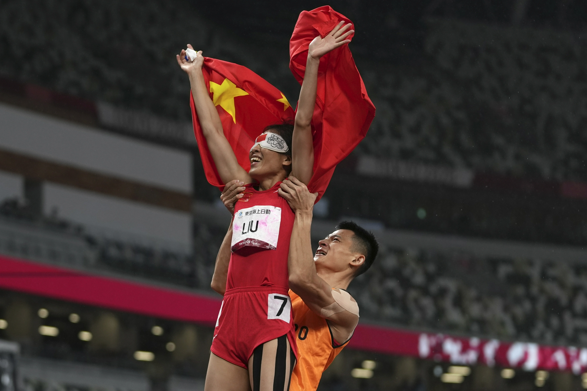 领跑员徐冬林高举盲人选手刘翠青。