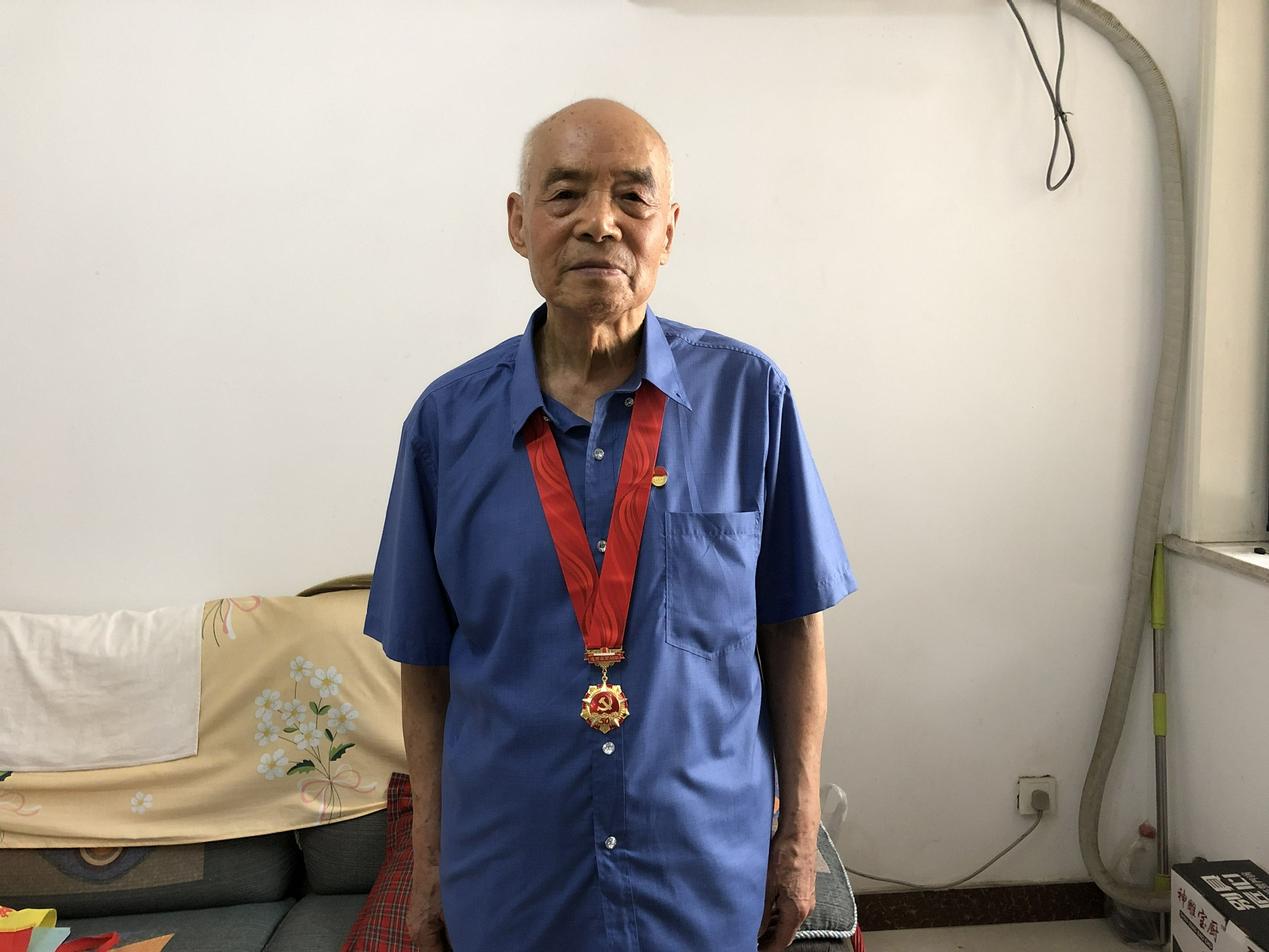 “七一”前夕，88岁高龄的宋振华获得了“光荣在党50年”奖章，他把它放在客厅显眼的位置，展示给记者看时小心翼翼地拿起，佩戴时一定要换上板正的衬衣，将奖章带服服帖帖地掖在领后。新京报记者 张静姝 摄