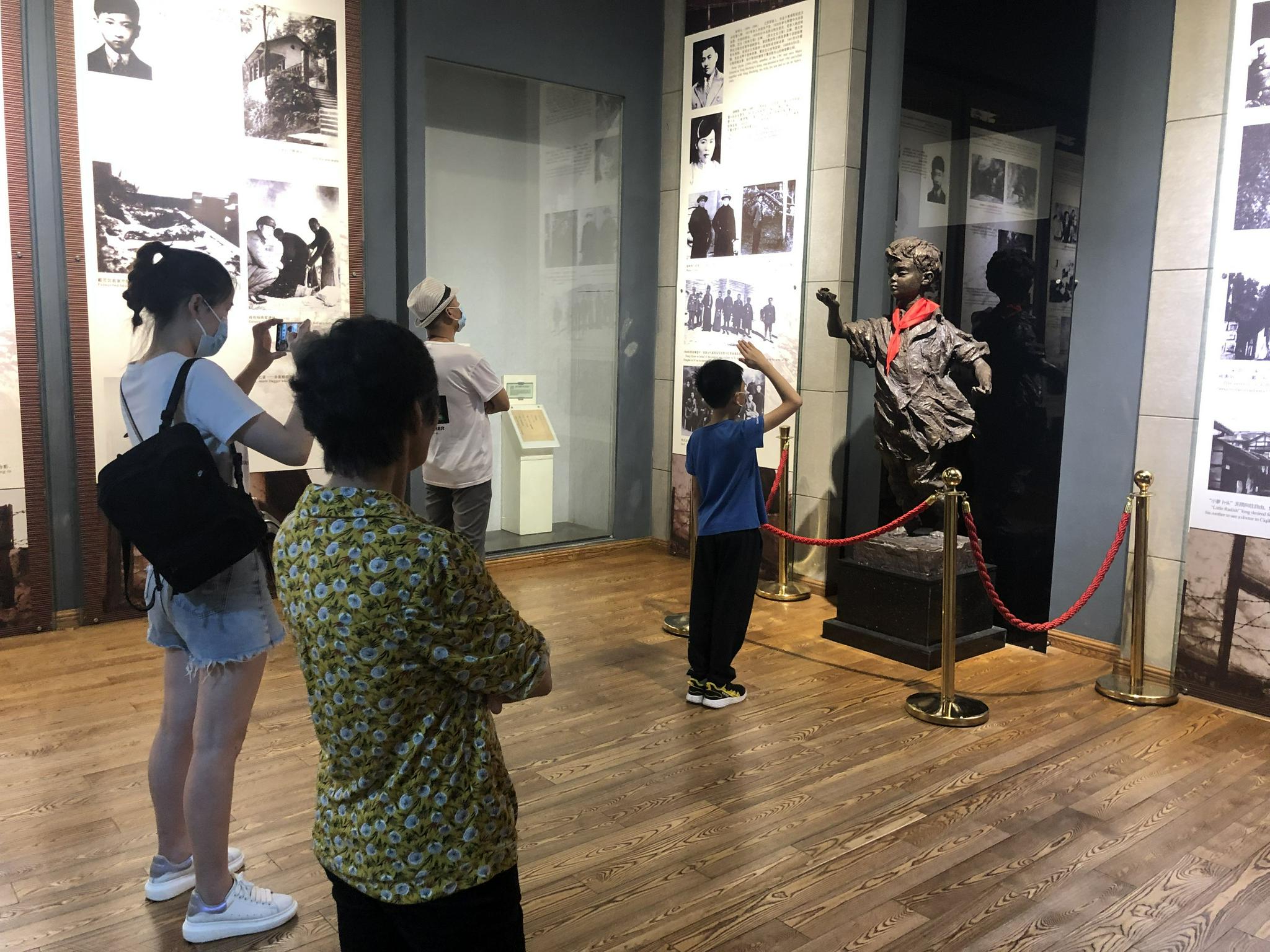 7月6日,重庆红岩魂陈列馆,一名小学生在小萝卜头雕像前敬少先队礼.