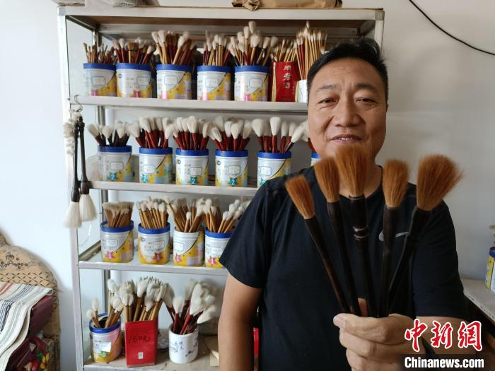 “崔氏毛笔”第三代传承人崔志刚展示手工制作的“狼毫小提”毛笔。王天译 摄