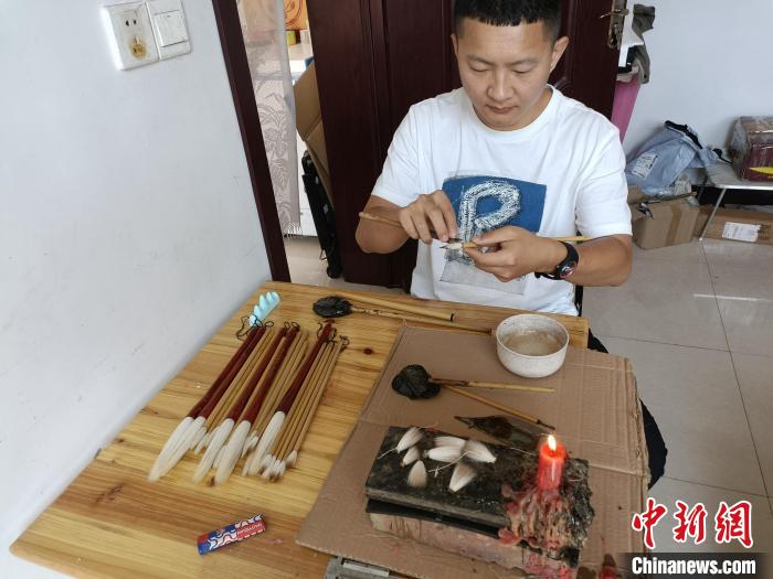 “崔氏毛笔”第四代传人崔大帅在完成制作毛笔的最后一道工序。王天译 摄