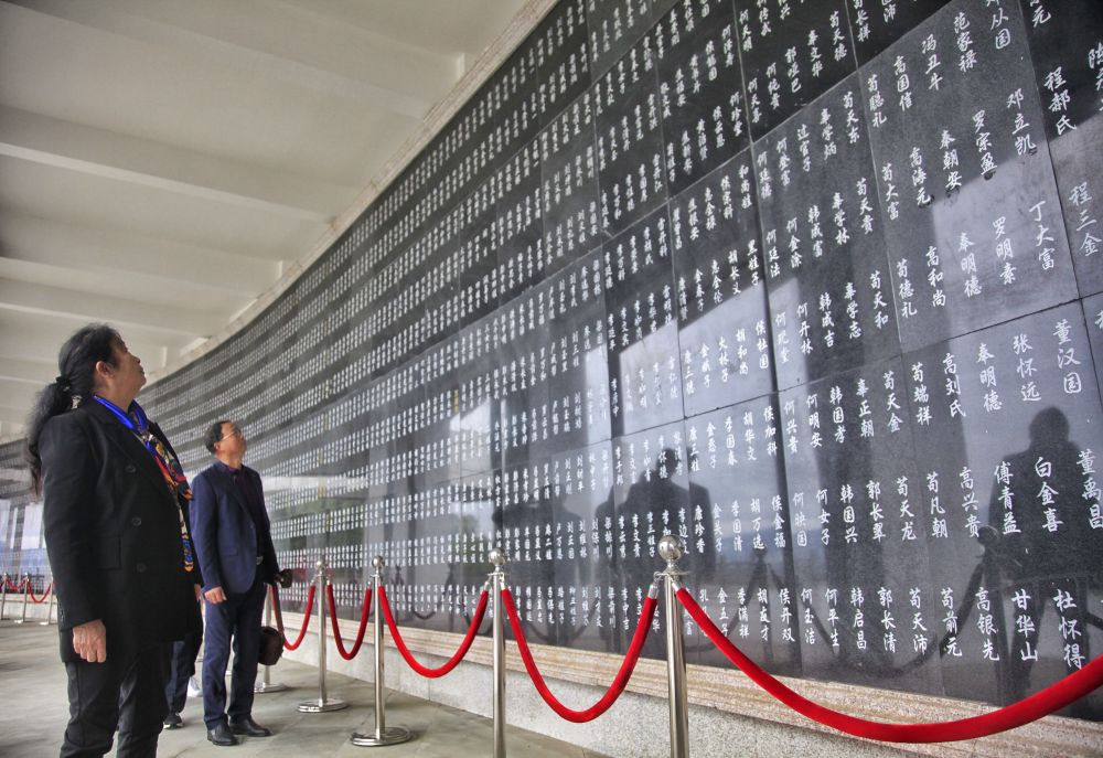 红军烈士后人在川陕革命根据地红军烈士陵园红军烈士纪念墙上找寻先辈