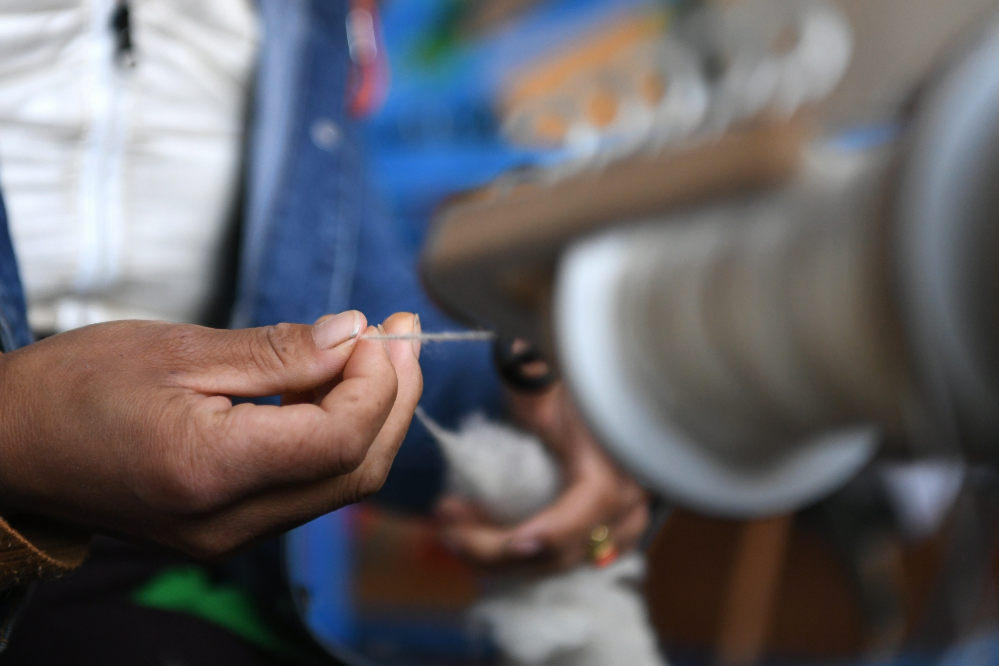 加科村村民拉周玛在藏族手工艺品车间里手工捻线(9月9日摄).