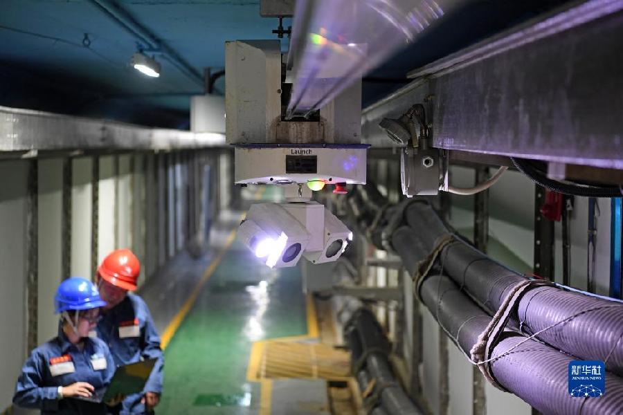 　　在珠海横琴综合管廊电力隧道里，南方电网工作人员操作巡检机器人对电缆隧道动态巡检（2019年12月12日摄）。新华社记者 梁旭 摄