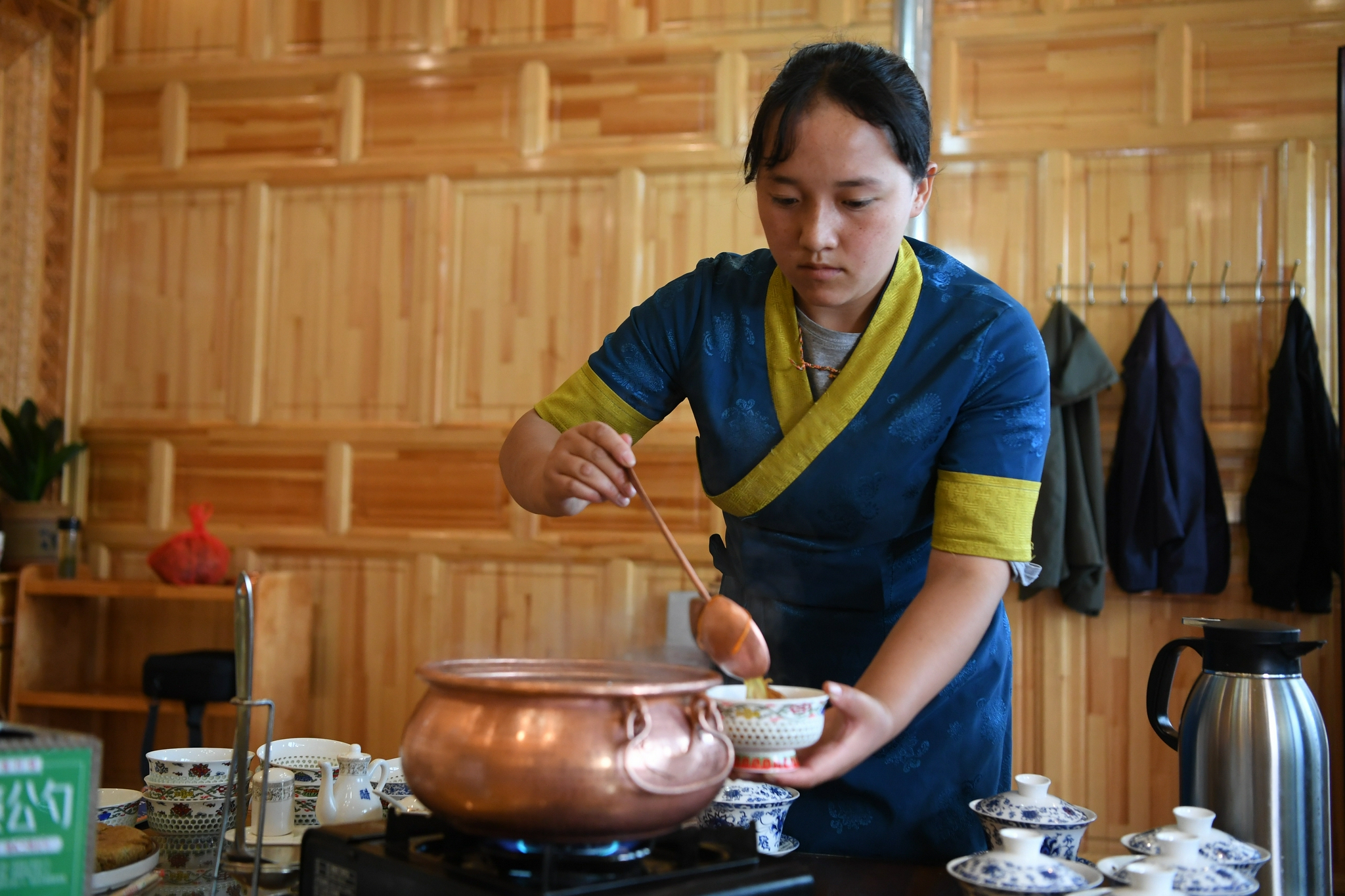 甘肃甘南卓尼县木耳镇力赛村村民拉姆卓玛在自家的农家乐里为客人盛汤