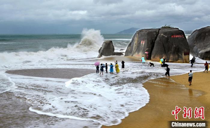 图为近日在三亚天涯海角旅游区嬉浪的游客。游建行 摄