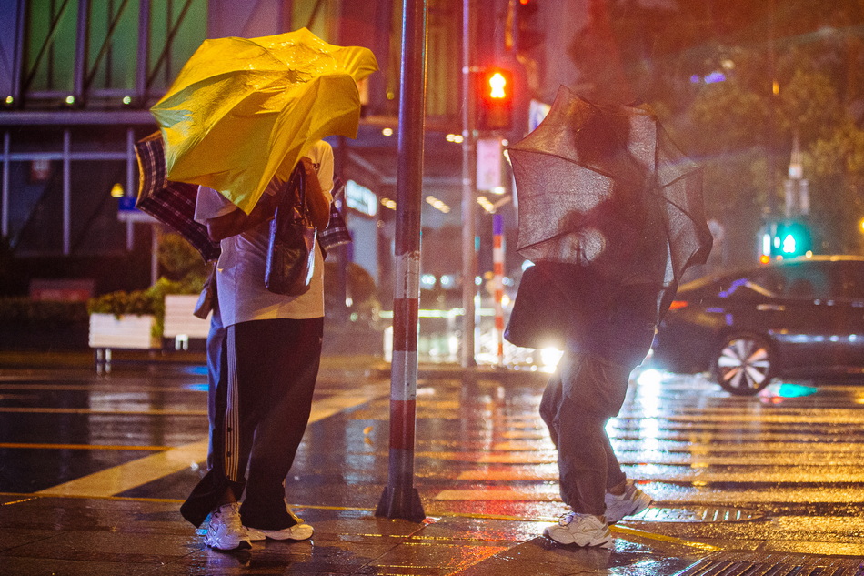 上海外滩晚高峰风雨影响持续伞被风吹飞