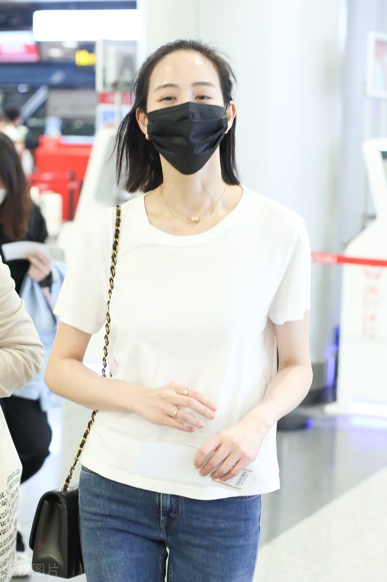 张钧甯戴黑色口罩,穿白色t恤搭配牛仔裤,脚踩平底鞋,休闲随性|张钧甯